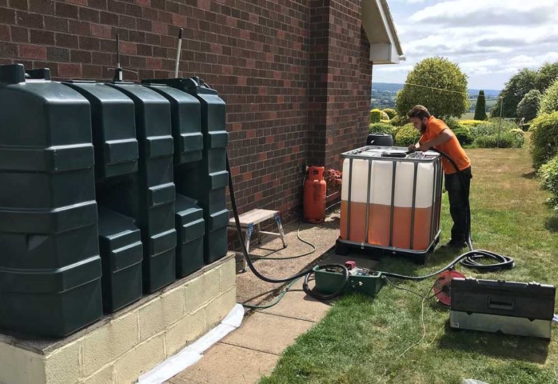 Engineer pumping heating oil from a domestic tank into a holding container